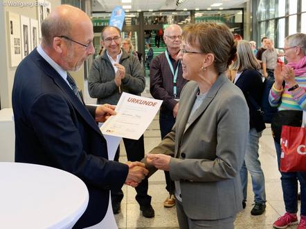 DVF Präsident Wolfgang Rau gratuliert der Siegerin Susanne Jung, im Hintergrund links: FIAP-Präsident Riccardo Busi